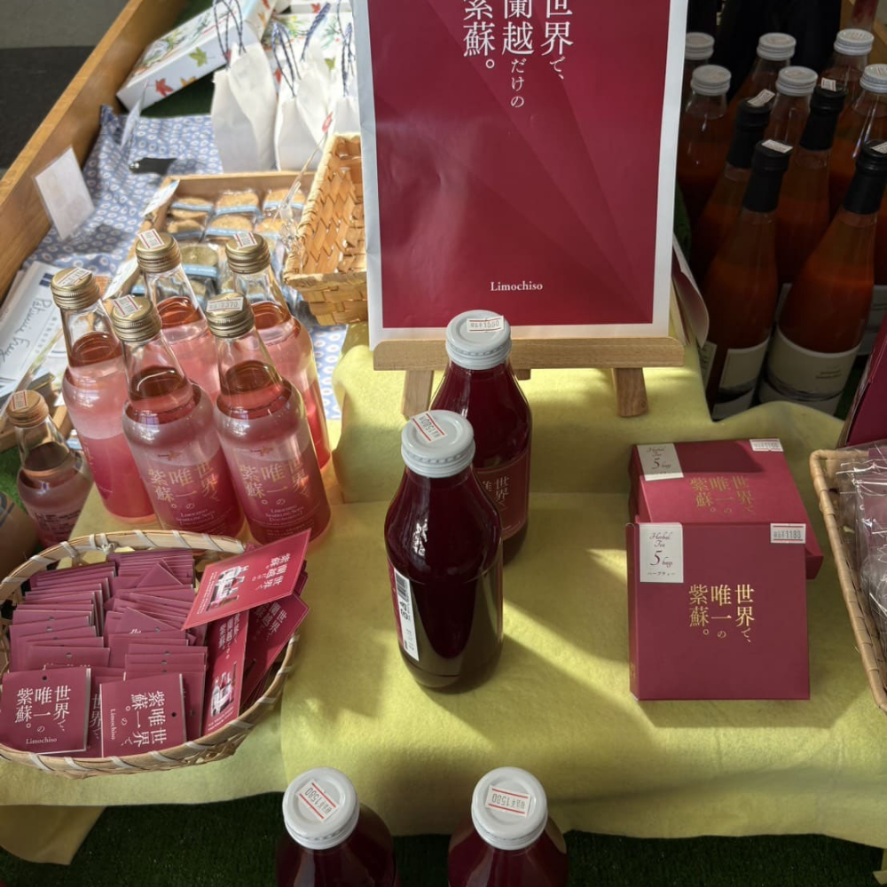 「シェルプラザ・港」の店内にある「Limochiso（リモチソ）」の赤シソ加工品コーナー。シソジュースの瓶やハーブティー、キャプションボードが並ぶ売場風景