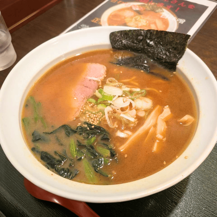 「らーめん むくげ」のラーメン。濃厚なスープにチャーシュー、海苔、ほうれん草、刻みネギがトッピングされている