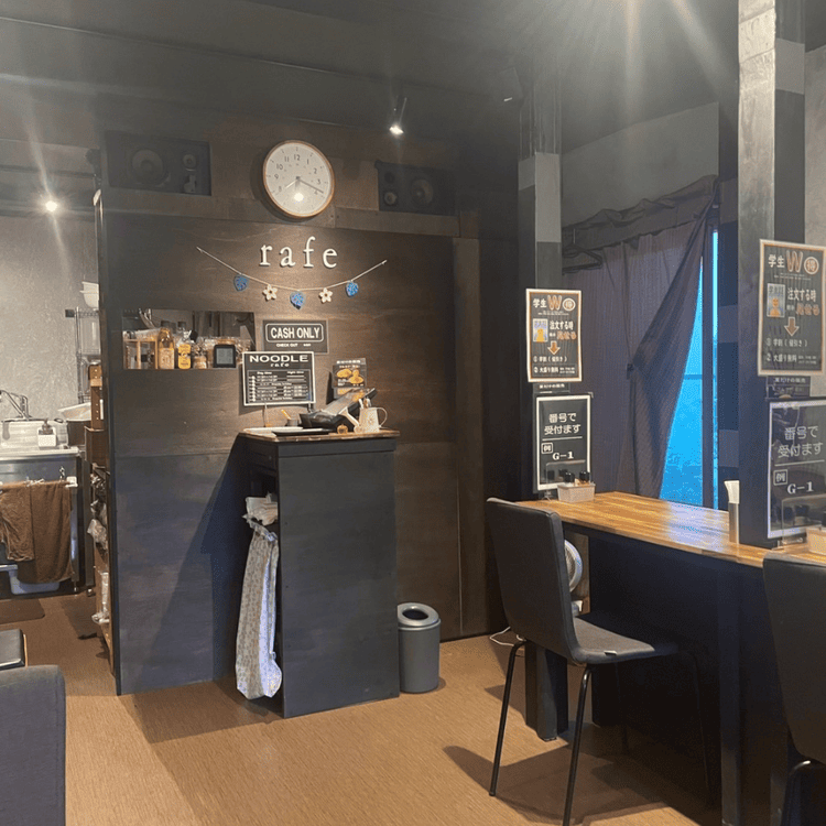 「NOODLE rafe」の店内風景。壁に「rafe」のロゴが飾られた落ち着いたシックなレジカウンターと木目調の客席