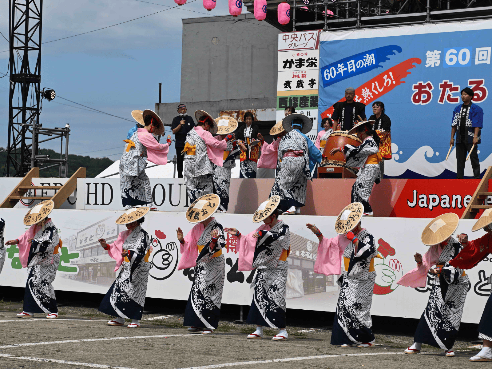 「第60回おたる潮まつり」のメインステージ上と手前のスペースで、高島越後盆踊りを踊る様子