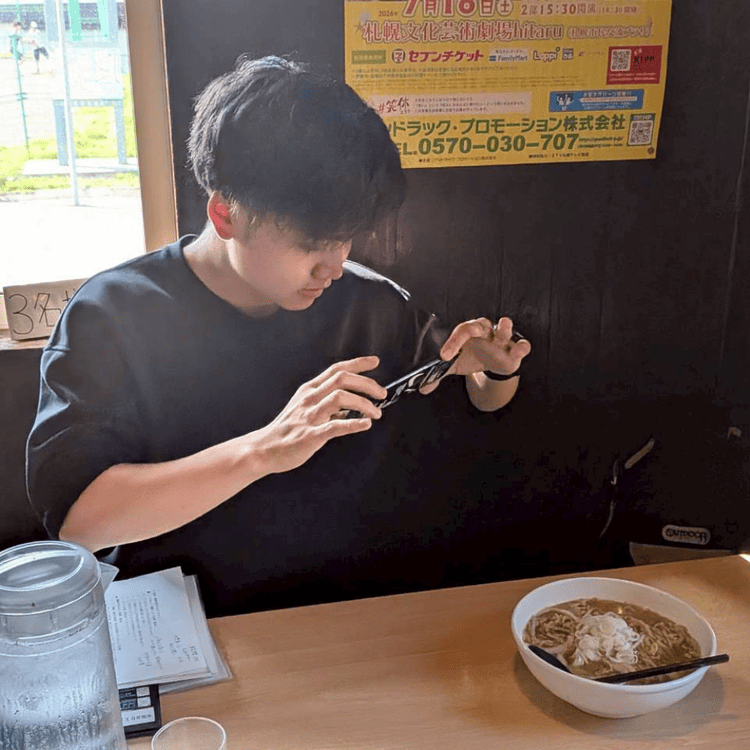 「おたる蔵屋」の店内で、運ばれてきたラーメンをスマートフォンで撮影する大学生の様子