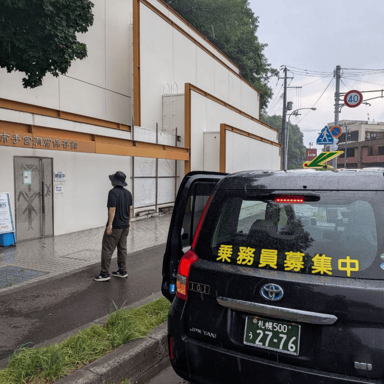 小樽市手宮洞窟保存館の建物外観と前に停車する観光タクシー