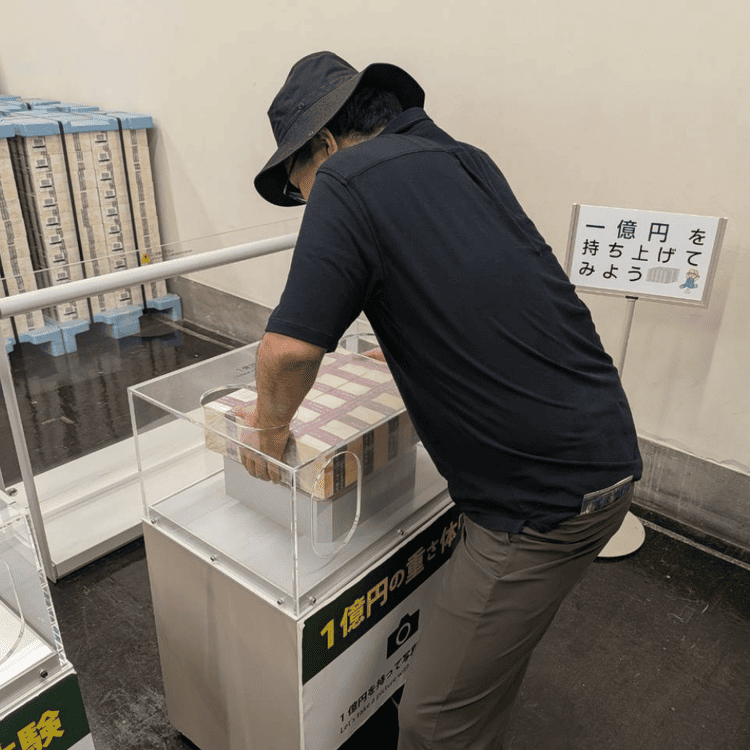 金融資料館（旧日本銀行小樽支店）で1億円の重さ体験をする様子
